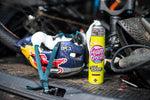 Muc-Off Helmet Foam Fresh 400ml placerad bredvid en cykelhjälm och tillbehör, perfekt för cyklister och utomhusentusiaster.